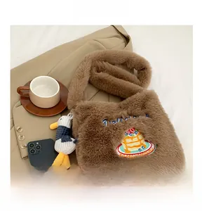 Détail du sac à bandoulière en peluche marron avec broderie et charm canard