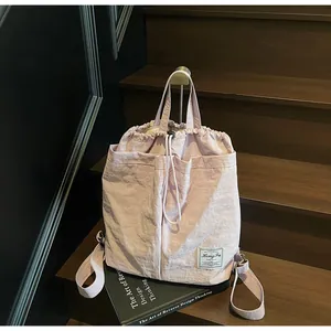 Zaino in nylon rosa resistente all'acqua appeso a una scala in legno scuro