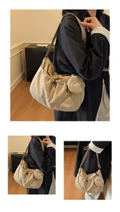 Detail view of khaki nylon crossbody bag with drawstring closure and coin pouch
