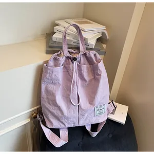 Dettaglio dello zaino in nylon lavanda con chiusura a coulisse e logo del marchio