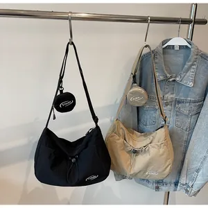Detail of nylon crossbody bag featuring drawstring pocket and detachable round coin purse
