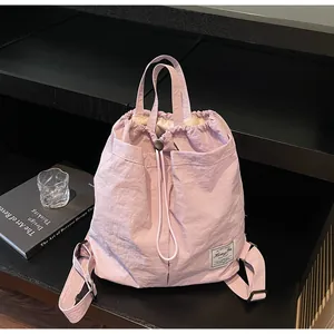 Dettaglio dello zaino in nylon impermeabile rosa chiaro con coulisse ed etichetta
