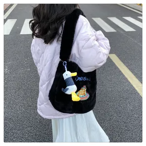Détail du sac cabas en peluche noire avec broderie délicieuse et breloque canard mignon