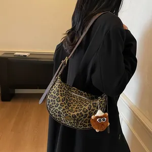 Hobo-Tasche mit Leopardenmuster, Plüschanhänger und Lederriemen in schlichtem Interieur
