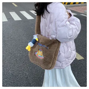 Détail du sac cabas en peluche marron avec broderie bleue et pendentif caneton mignon