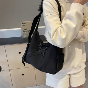 Black waterproof nylon messenger bag with wide shoulder strap and multiple zipper pockets