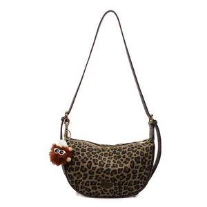 Hobo-Tasche mit Leopardenmuster, Plüsch-Anhänger und braunem Kunstlederband auf Weiß