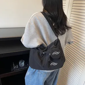 Minimalist black nylon crossbody bag with small round coin pouch for outdoor travel