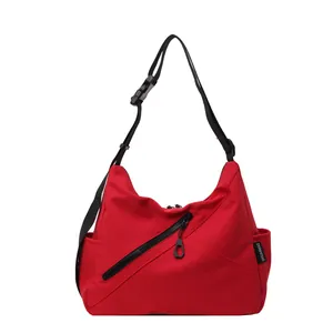 Large red crossbody gym bag with wide adjustable shoulder strap and diagonal zipper