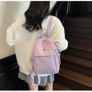 Vue détaillée du dos d'un sac à dos en nylon lavande porté par une femme sur un modèle