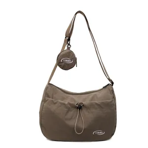 Minimalist earth tone nylon crossbody bag with matching round coin pouch and logo