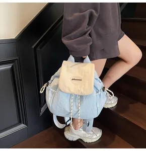 Dettaglio dello zaino leggero in nylon blu e crema con coulisse e patta di chiusura regolabile