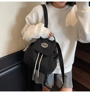 Dettaglio dello zaino in nylon nero con chiusura a coulisse e corde intrecciate bianche