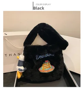 Détail d'un cabas noir en peluche avec broderie bleue et charmant canard en peluche