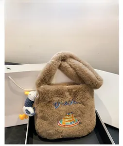 Détails d'un sac en peluche marron café avec broderie gâteau et pendentif canard