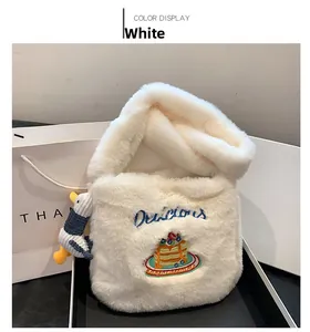 Détail du sac cabas blanc pelucheux avec broderie gâteau et breloque petit canard