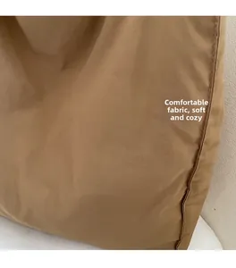 Detailed close-up of soft khaki canvas fabric texture and neat stitching on shoulder bag