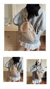 Détail du sac à dos en nylon kaki avec compartiments et poches latérales à cordon