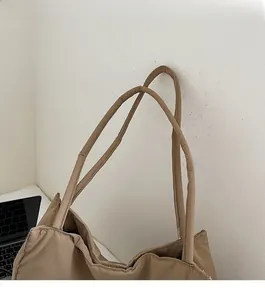 Detail of khaki tote bag featuring soft padded shoulder straps and durable nylon fabric