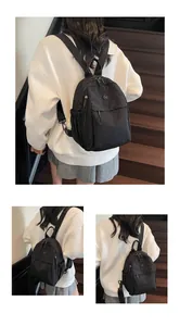 Détail d'un sac à dos en nylon noir avec emblème circulaire et poches latérales