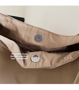 Detail view of the magnetic closure and internal zipper pocket on the canvas tote bag