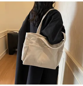 Detail of corduroy tote bag showing vertical texture and convenient side pocket for storage