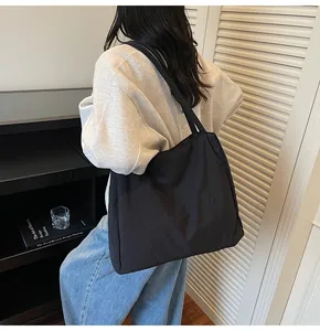 Lifestyle view of a large black canvas tote bag worn by a model in casual setting