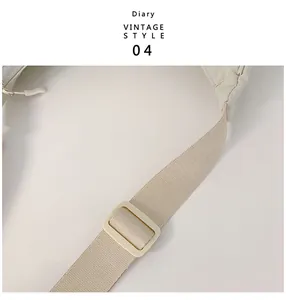 Detailed close-up of adjustable woven shoulder strap and buckle on beige crescent bag