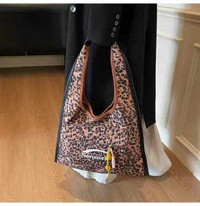 Detail of leopard print canvas tote with front pocket and colorful tassel accents