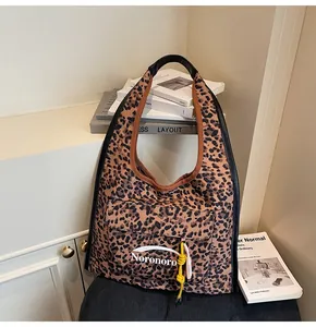 Detail of leopard print tote bag with front pocket and decorative woven tassel