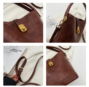 Detail view of vintage brown bucket bag with gold hardware and adjustable strap textures