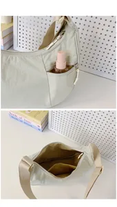 Detail view of light green nylon crescent bag with front zipper and internal pocket
