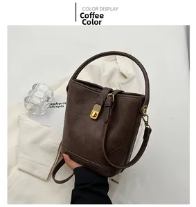 Detailed view of the coffee brown leather bucket bag with golden metal rotary lock