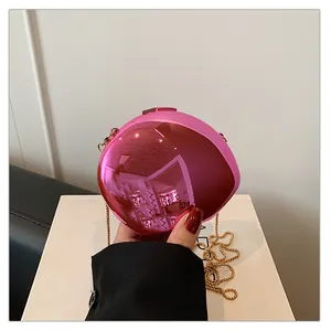 Detailed close-up of glossy pink acrylic evening bag with gold chain strap