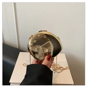 Close-up of a gold mirror finish egg-shaped clutch bag with sleek metal chain strap