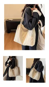 Detail view of large cream fabric tote bag with long shoulder straps and pleated texture