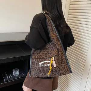 Leopard print canvas tote bag with front pocket and decorative pendant on female model