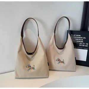 Detail of embroidered animal design on high-quality canvas tote bag with leather straps