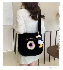 Close-up of black fuzzy tote bag with donut embroidery and cute duck plush charm