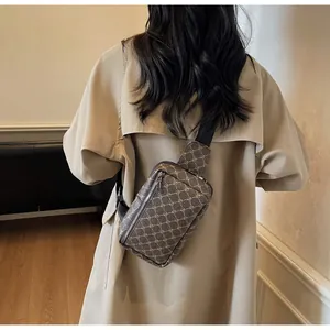 Herren Brusttasche mit braunem Monogramm-Muster getragen über einem beigen Mantel