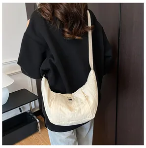 Close-up of beige nylon tote bag with drawstring details and adjustable shoulder strap
