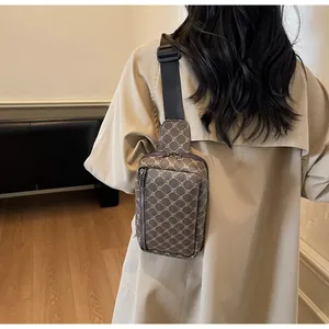 Detail der karierten Umhängetasche mit verstellbarem Nylongurt, am Modell präsentiert
