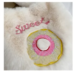 Detailed macro view of soft plush fabric with sweet text and colorful donut embroidery