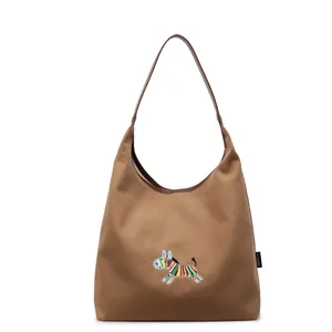 Brown canvas hobo tote bag with colorful zebra embroidery and wide shoulder strap