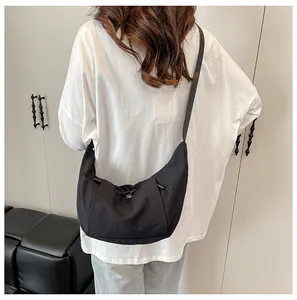 Detail of minimalist black canvas crescent bag with adjustable shoulder strap and drawstring