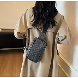 Detail der grauen geometrischen Brusttasche mit Reißverschluss auf khakifarbenem Trenchcoat