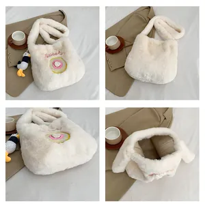 Detailed close-up of fuzzy cream tote bag with sweet donut embroidery and plush bird charm