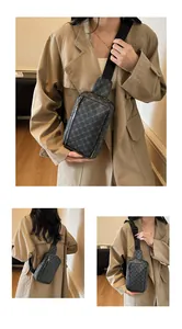 Detailansicht der dunkelgrauen Brusttasche mit geometrischem Monogramm und Reißverschluss