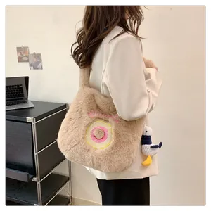 Detail of khaki plush shoulder bag with donut embroidery and seagull charm pendant