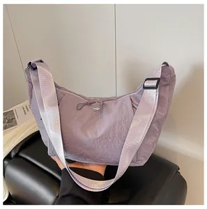 Macro detail of lavender nylon crescent bag showing pleated texture and adjustable strap
